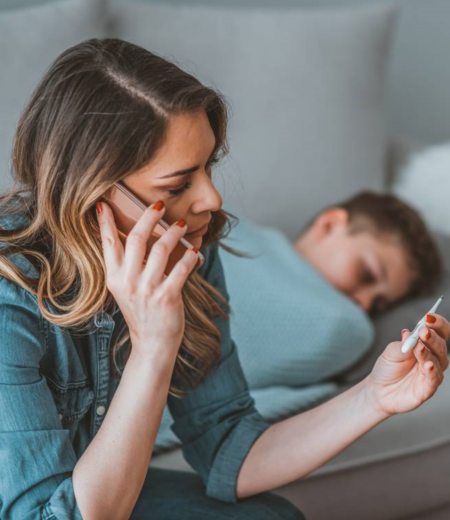  Concerned parent checking her child's temperature with a thermometer.